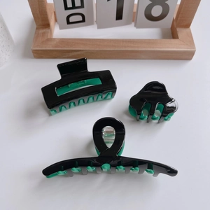 Three-piece black and green acetate hair claw clips set with minimalist color blocking