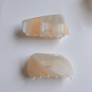 French style acetate hair claws in marble orange and cream with gold lettering