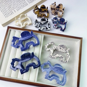Detail of cute dog-shaped cellulose acetate hair claws in various marble and tortoiseshell patterns