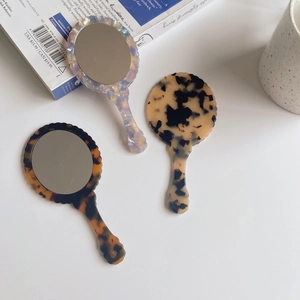 Chic vintage acetate hand mirrors with wavy frames in tortoiseshell and pearl textures