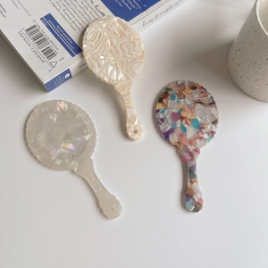 Retro acetate hand mirrors with wavy edges in pearl white and marble patterns