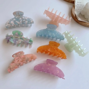 Elegant acetate hair claws in pastel marble patterns and floral textures for women