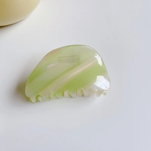 Détail de la texture marbrée vert clair sur la pince à cheveux en acétate polie