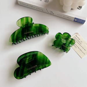Three-piece set of dark green acetate hair claws with elegant marble texture and gold accents