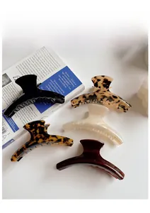 Five-piece large acetate hair claw clips set in tortoiseshell and solid colors with gold logo