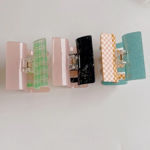 Detail showing various checkered, marble, and glitter textures on square acetate hair claws