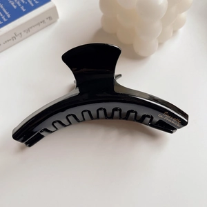Close-up of black acetate hair claw with gold Barrette La France lettering on white background