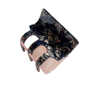 Pink and marble patterned acetate claw clip with large grip teeth on white background