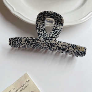 Macro detail of French style acetate hair claw clip with black and white tortoiseshell pattern