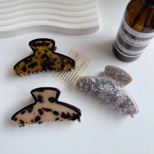 Tre fermagli per capelli in acetato con motivi tartarugati e marmorei su pietra