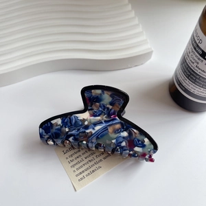 Dettaglio della molletta per capelli in acetato marmorizzato blu con finitura elegante