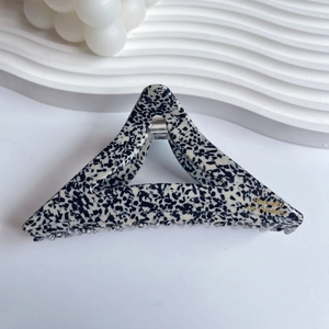 Vue détaillée de la grande pince à cheveux en acétate avec motif terrazzo noir et blanc
