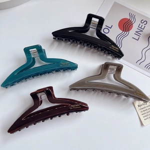 Set of minimalist large acetate claw clips in four colors with gold barrette lettering