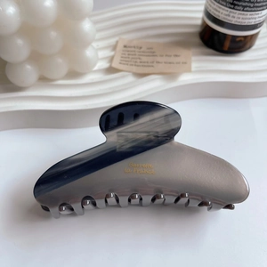 Detailed macro view of gray acetate hair claw clip with golden Barrette La France text