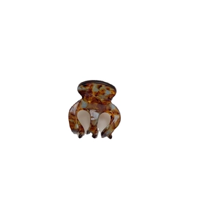 Minimalist acetate hair claw clip with classic tortoiseshell pattern on white background