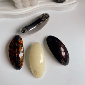 Detail view of acetate hair clips in four elegant patterns with metal spring fastener