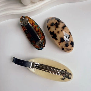 Three-piece set of oval acetate hair clips in tortoiseshell and cream resin finishes