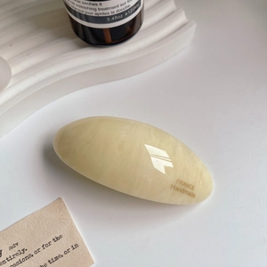 Macro view of handmade cream acetate hair clip with marble texture and polished finish