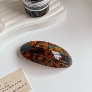 Detail of tortoiseshell pattern hair clip with gold France Handmade lettering