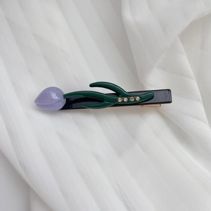 Vue détaillée de la pince à cheveux tulipe en acétate violet avec strass ambrés brillants