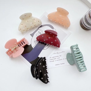 Close-up of six assorted French acetate hair claws with rhinestone floral accents