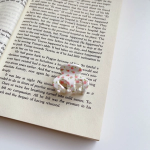 Detail der Blumen-Haarklammer mit rosa Blüten auf einem Buch für einen Vintage-Look