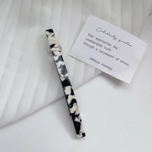 Close-up of black and white marble acetate hair clip with strong metal spring fastening