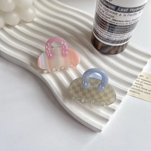 Chic acetate hair claw clips with marble and checkerboard patterns on a tray
