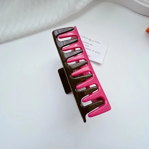 Close-up of a two-tone large hair claw clip in coffee and rose pink with a glossy finish