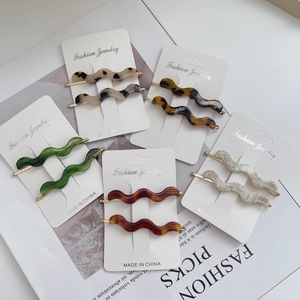 Set of 10 vintage acetate wavy hair clips in assorted colors on fashion magazine
