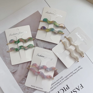 Retro acetate wavy hair clips in four colors with gold metal backing and card packaging