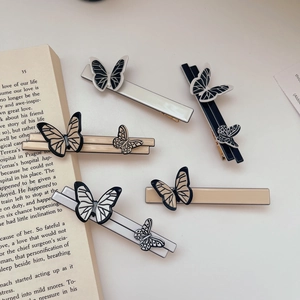 French vintage acetate butterfly hair clip set in black and white on a book
