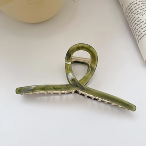 Detailed view of large olive green acetate shark hair claw clip with silver metal spring