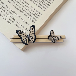 Close-up of French vintage acetate butterfly hair claw clip on an open book