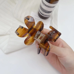 Close-up of tortoise shell flower hair claw clip with acetate finish and metal spring