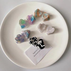 French heart-shaped acetate hair claw clips in colorful marble and cow print patterns