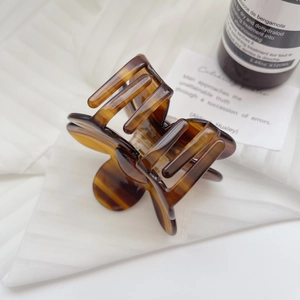 Detail of amber tortoiseshell hair claw clip made of premium acetate with high-gloss finish