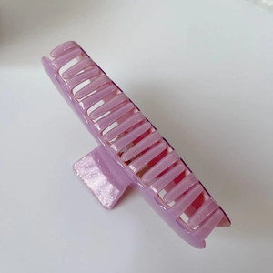Vue détaillée de la pince à cheveux en résine violette avec finition à paillettes