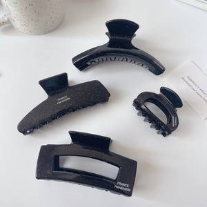 Vue macro détaillée de pinces à cheveux noires pailletées avec marquage FRANCE Handmade