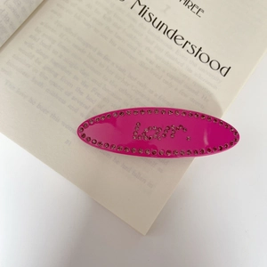 Close-up of rose red acetate hair clip with sparkling rhinestones and love letter design