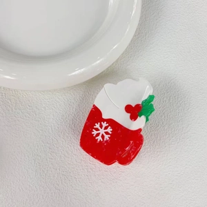 Macro detail of Christmas acetate hair claw featuring a red mug and festive snowflake motif