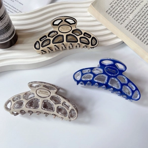 French acetate hair claw clips in marble and blue colors with cutout geometric design