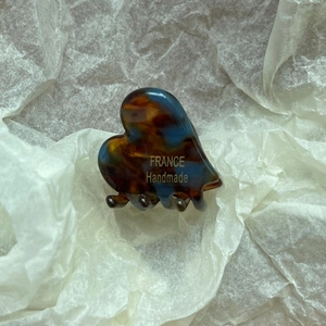 Detail of vintage heart-shaped acetate hair claw clip with France Handmade lettering