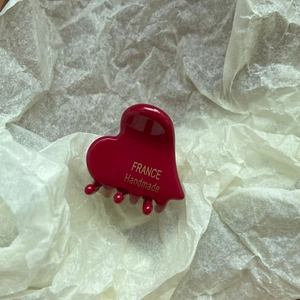 Macro shot of glossy red heart hair claw with golden France Handmade engraving