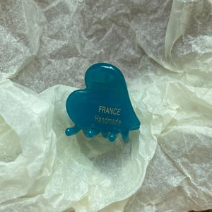 Detail view of heart-shaped acetate hair claw clip with golden France Handmade lettering