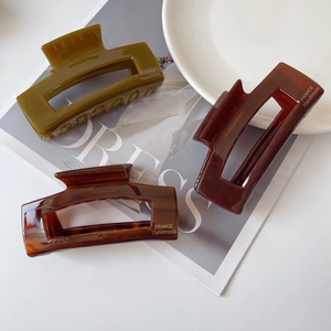 Three large acetate hair claws in dark green, coffee and tortoiseshell for women