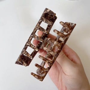 Detail view of a large rectangular acetate claw clip with vintage brown tortoiseshell patterns