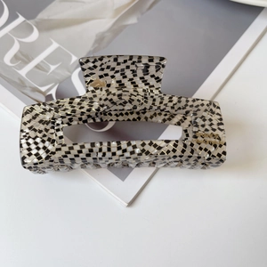 Detail of checkered acetate hair claw clip with golden France Handmade lettering