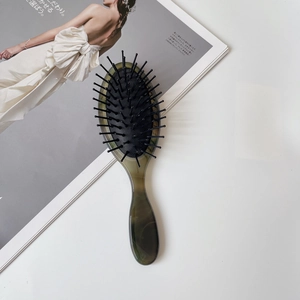 Detail van de groene marmeren handgreep op de massage haarkom met zwarte borstelharen