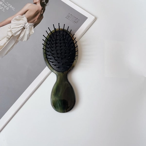 Detail van een smaragdgroene marmeren acetaat haarkamer op een modetijdschrift
